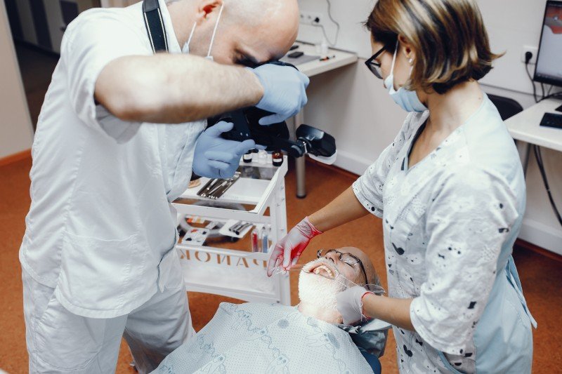 Dentist performing a comprehensive dental examination on a patient during full mouth rehabilitation