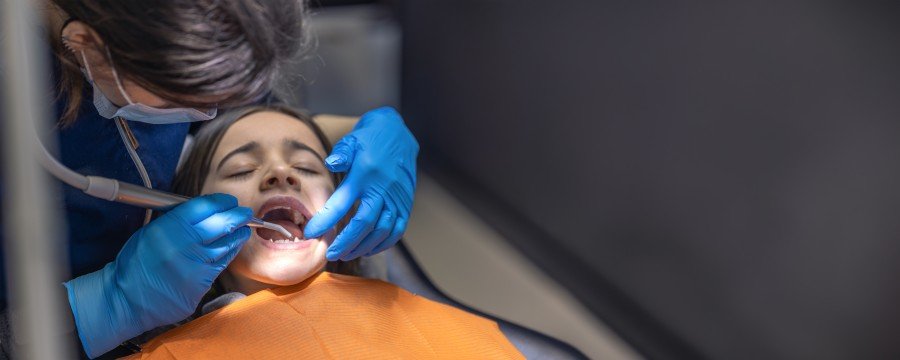 Dentist examining a child’s teeth during a dental treatment
